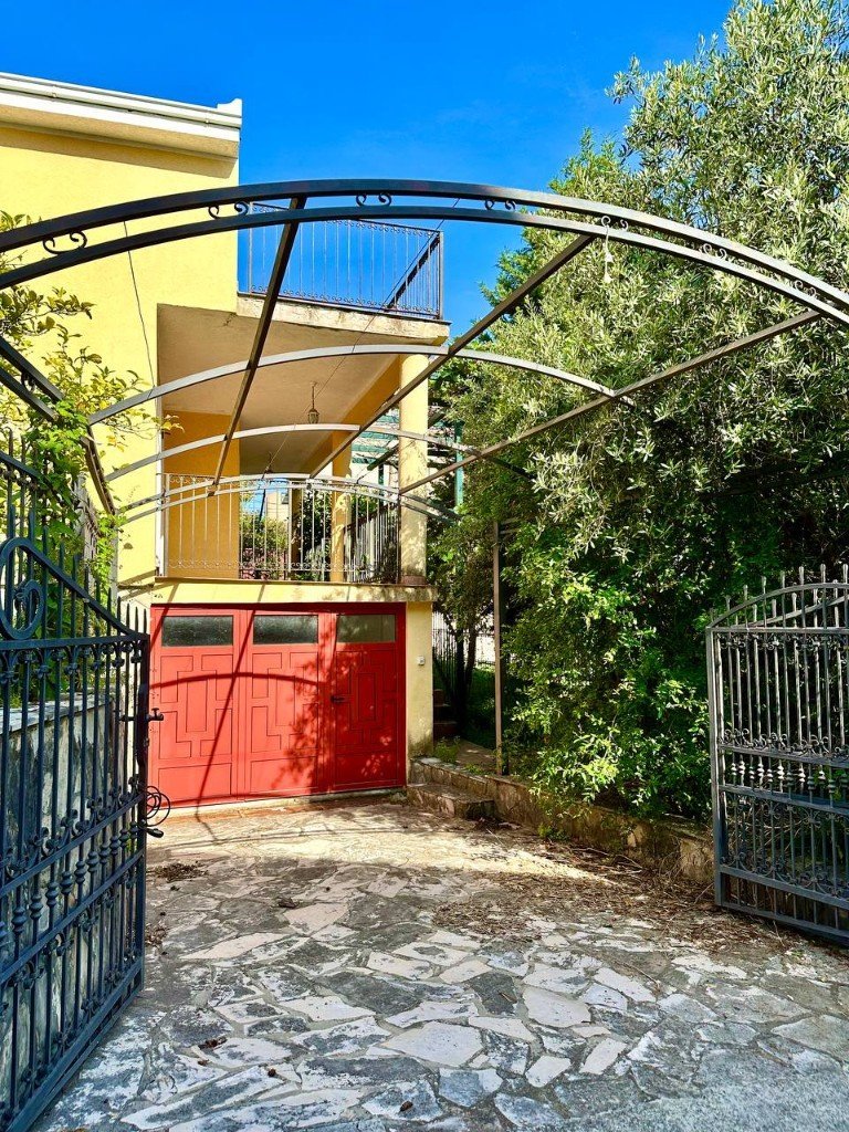 Đenovići house entrance with red garage door