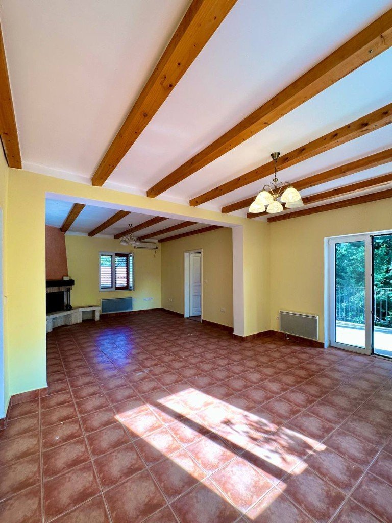 Đenovići house living area with fireplace and wooden beams