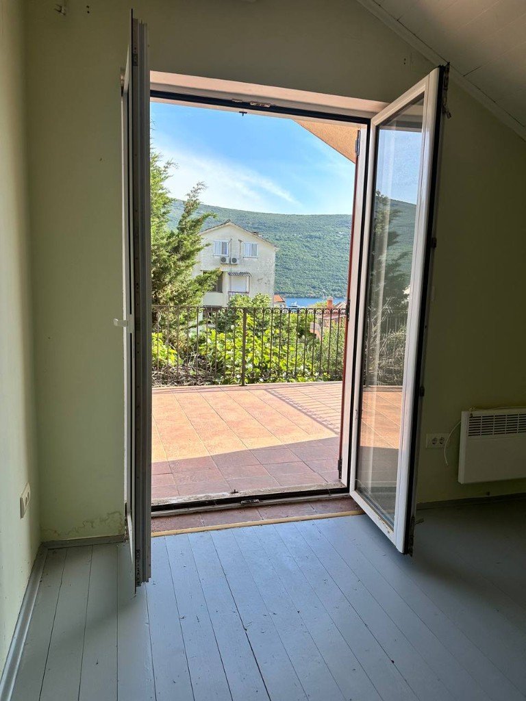 Đenovići house bedroom opening onto balcony with sea view