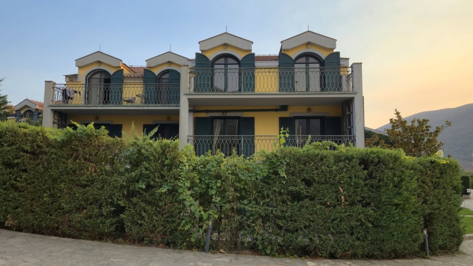 Lastva House yellow facade with grape vines and balconies